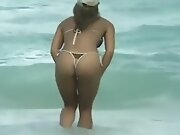 Topless Sunbathers On Beach